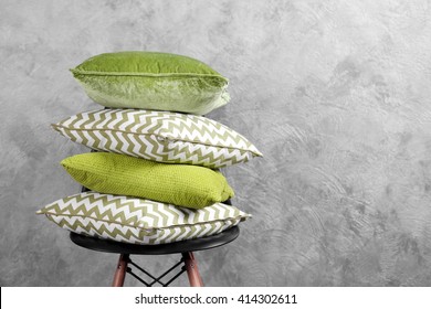 Few pillows on chair against blue wall background