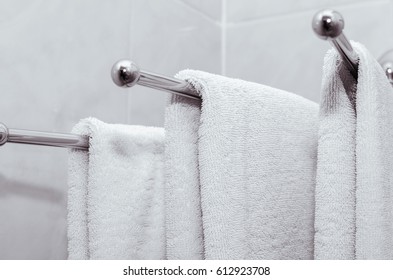 A few white towels hanging on the hook in the bathroom - Powered by Shutterstock