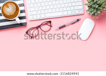 ffice desk with computer, Pen, Notebook, eyeglass, mouse and Cup of coffee on pink background, Top view with copy space, Mock up.	