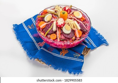 
Fiambre  (traditional Guatemalan Family Dish Eaten On Nov 1, All Saints' Day / Day Of The Death), Mix Of Cold Cuts, Sausages, Vegetables. Served On A Guatemalan Textile, Isolated On White Background.