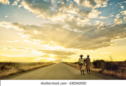 Fianarantsoa, Madagascar, November 2012. Two Women Are Going Back Home From A Village In The Middle Of A Desert. The Fantastic Sunset Behind Them Show The Amazing Colors Of The African Sunset.