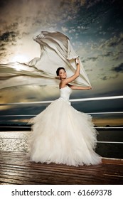 Fiance in the wind. Pretty lady in a wedding dress on deck.