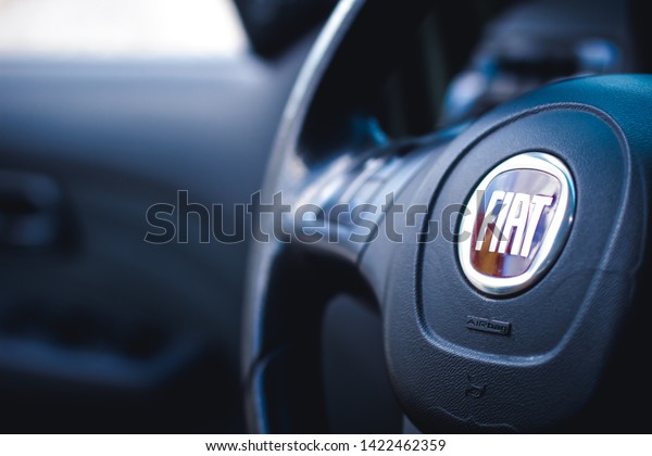 Fiat, cars, brands. Photo of the interior of a car Fiat\
Pálio Weekend 1.8 model 2016. Highlight the vehicle steering wheel\
with a company logo. Brasília, Federal District - Brazil. June, 11,\
2019. 