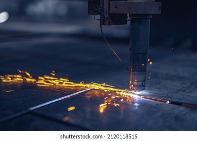 Fiber laser cutting CNC machine cuts metal list. Making metal part. Metal cutting process with sparks. Workshop in factory. 