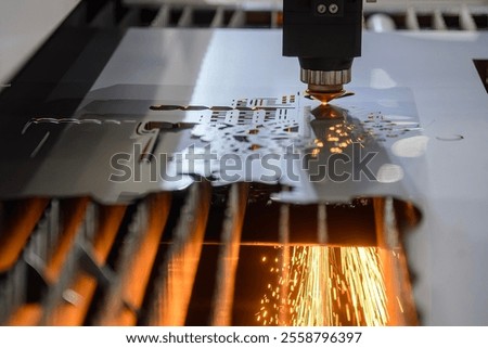 The fiber laser cutting machine  cut the metal plate with the sparkling light. The hi-technology sheet metal manufacturing process by laser cutting machine. 