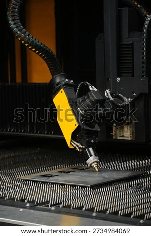 fiber laser cutting machine head with nozzle precisely cutting contours in sheet metal plate for high-precision part fabrication