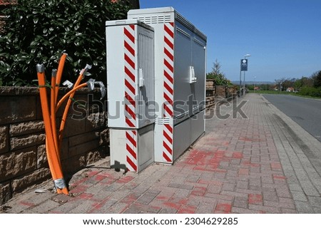 Fiber optic cable ends next to a junction box on a village street