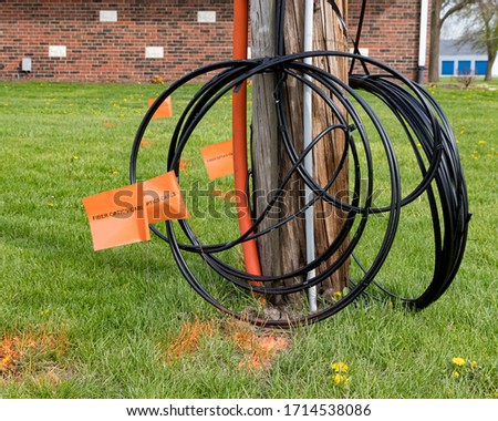 Fiber optic cable, orange marking flags and utility pole. Concept of digging safety, utility locate service and high speed internet.