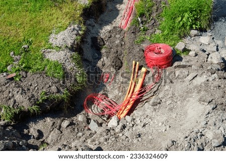 fiber optic cables been installed underground in dug trenches front of residential homes. Installation connecting of fibre optic cables to neighbouring houses