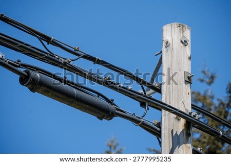Fiber optic splice closure on utility pole against blue sky