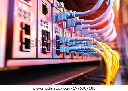Fiber Optical cables connected to an optic ports and Network cables connected to ethernet ports