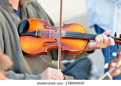 A fiddler entertains at an outdoor event.