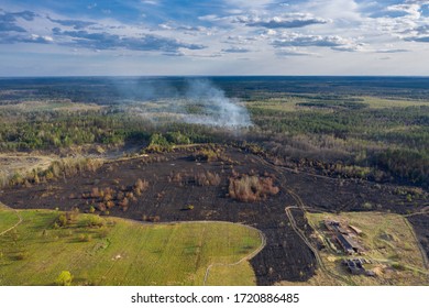 Field and forest after wildfires. The forest is still in smoke. Natural disasters or arson in April 2020.  Ditches to prevent the spread of fire. Old sawmill. North of Ukraine, Zhytomyr region.