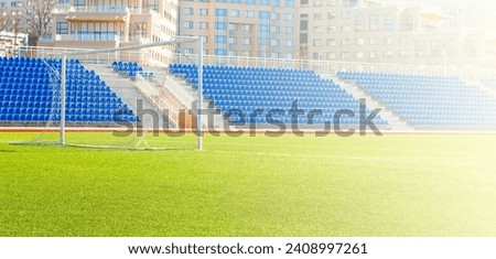 Field for game in soccer with a gate and bleachers on soft sunlight