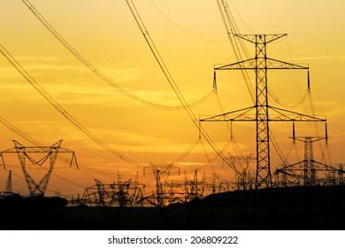 field of high voltage towers under dramatic sky