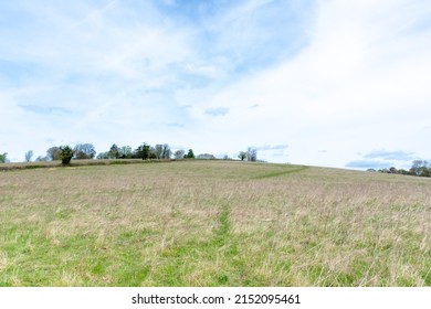 A field with a hill and blue skyin Chorleywood hertfordshire.