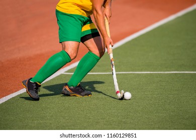 Field Hockey Player, In Possesion Of The Ball, Running Over An Astroturf Pitch, Looking For A Team Mate To Pass To