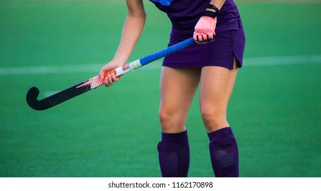 Field Hockey Player, In Possesion Of The Ball, Running Over An Astroturf Pitch, Looking For A Team Mate To Pass To