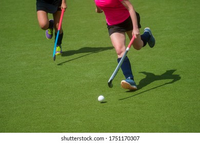 Field Hockey Player, In Possesion Of The Ball, Running Over An Astroturf Pitch, Looking For A Team Mate To Pass To