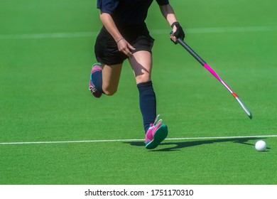 Field Hockey Player, In Possesion Of The Ball, Running Over An Astroturf Pitch, Looking For A Team Mate To Pass To