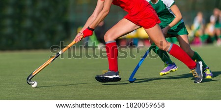 Field Hockey player, ready to pass the ball to a team mate. Hockey is a team sport. 