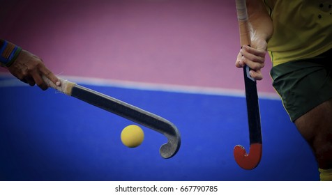 Field hockey players control the ball.