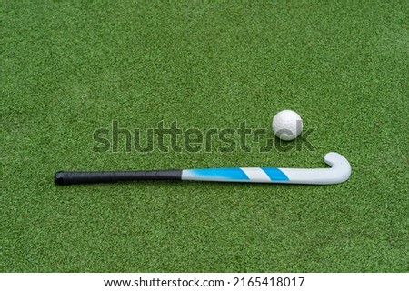Field hockey stick and ball on green grass.  Horizontal sport theme poster, greeting cards, headers, website and app