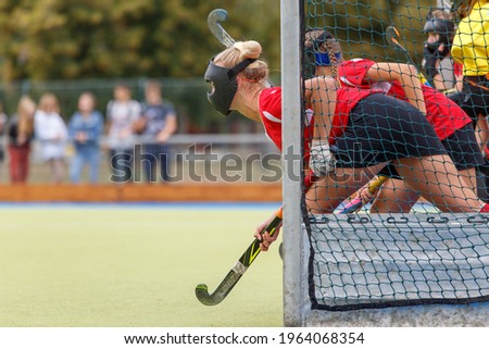 Field hockey woman player in the net waiting for the penalty shot. Penalty shot in field hockey game image with copy space