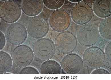 Field Of Japanese Coins At 1 Yen. Dark Background Or Wallpaper. News About The Economy, Finances And Interest Rate Of The Central Bank Of Japan. Deflation And Depreciation Of The National Currency