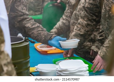 A Field Kitchen Cook Pours Food For Soldiers At A Halt.