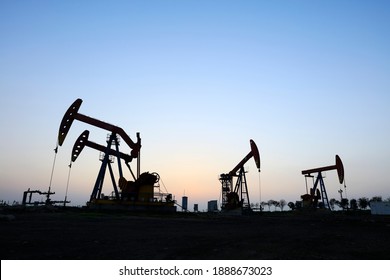 Im Feld, die Ölpumpe am Abend, die Abendsilhouette des Pumpwerks, die Silhouette der Ölpumpe