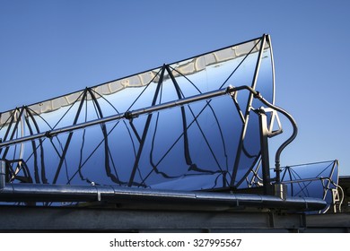 Field Of Parabolic Solar Reflector Panels For Heating Water On A Car Park Roof.