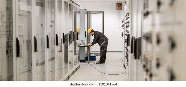 Field service engineer inspect relay protection system with laptop computer. Bay control unit. Medium voltage switchgear
