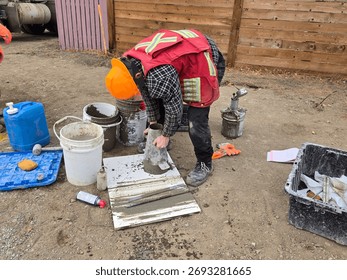 Field technician performs slump test on fresh concrete sample to determine consistency and workability during foundation pour quality control.