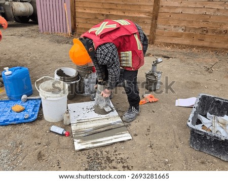 Field technician performs slump test on fresh concrete sample to determine consistency and workability during foundation pour quality control.