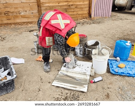 Field technician performs slump test on fresh concrete sample to determine consistency and workability during foundation pour quality control.