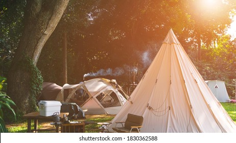 Field Tents Group And Wooden Table Set With Outdoor Kitchen Equipment In Camping Area At Natural Parkland