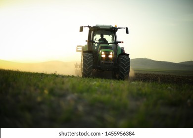 In The Field, Tractor Harvesting. Farmer Trying To Finish Sunset Works With His Tractor.