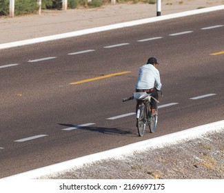 A Field Worker Riding His Bike Back Home After A Long Working Day