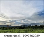 The fields and the cloudy sky.
