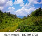Fields open in the mountains to a view