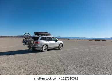 Fields, Oregon \ USA - 31 August 2019:  Honda Pilot car with Yakima cargo box on the roof and bike racks covered in dust in the middle of Alvord desert, south Oregon