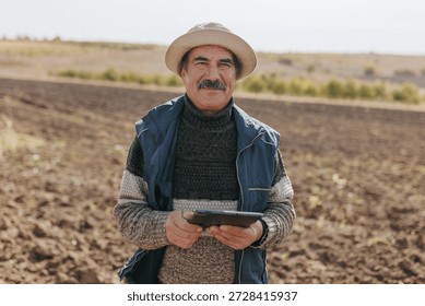 Fields of Wisdom The image captures an elderly worker with digital tablet gaze, wise and contemplative, set against the vastness of the agricultural expanse he has nurtured throughout the years.