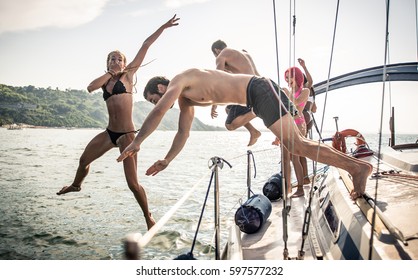 Fiends having fun on a sail boat and jump in the water