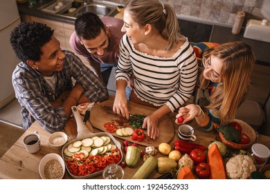 Fiends preparing vegetarian meal.They preparing food and making fun in the kitchen.Home party. - Powered by Shutterstock