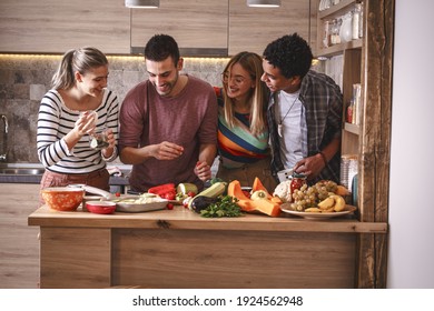 Fiends preparing vegetarian meal.They preparing food and making fun in the kitchen.Home party. - Powered by Shutterstock