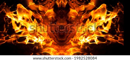 The fiery face created by the tongues of fire resembles the tales of legends and beliefs in the underworld and devils, red crimson orange colors and black smoke soot