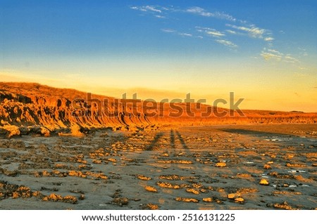 Fiery red eroded rocks at sunset at the coast of Cape Keraudren, a remote area between Port Hedland and Broome in Western Australia.Rocky beach with small pools. Part of Eighty Mile Beach Marine Park.