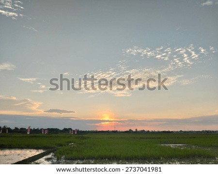 Fiery red sunset sky glowing above the horizon, with warm tones blending across soft clouds to create a dramatic and peaceful evening atmosphere.