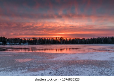 A fiery sunrise reflects off of the ice of a frozen lake in Northwest Ontario, Canada. - Powered by Shutterstock